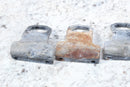 Three corroded metal brackets.