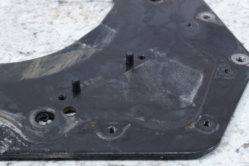 Black, irregularly shaped plate with mounting holes and cylindrical protrusions.