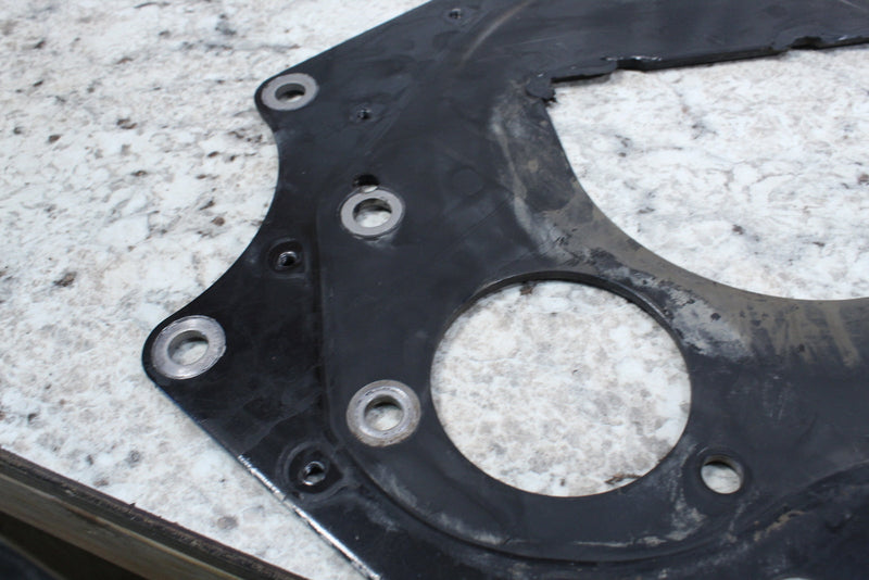 Black metal adapter plate with circular openings.