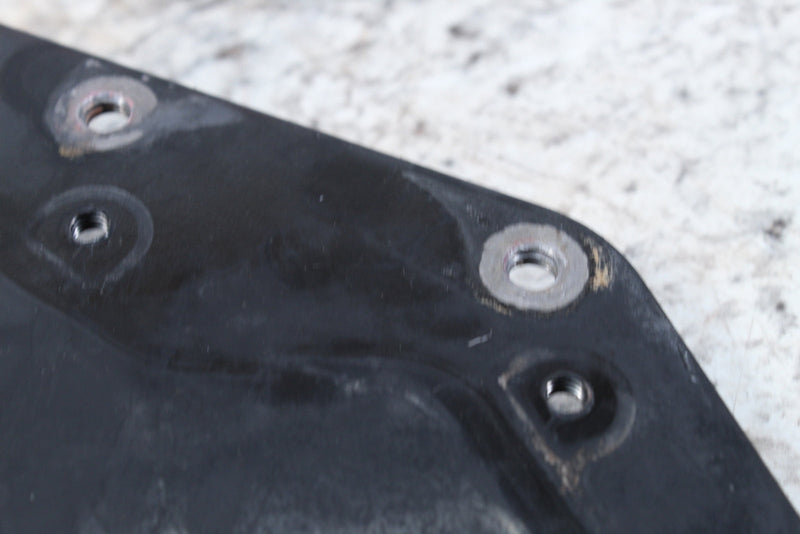 Black plastic panel with metal-reinforced holes.