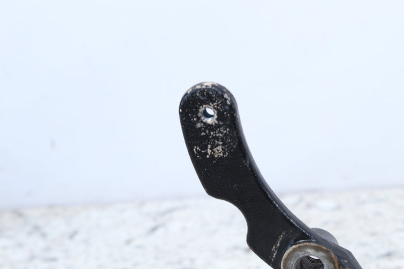 Black metal linkage with mounting holes.