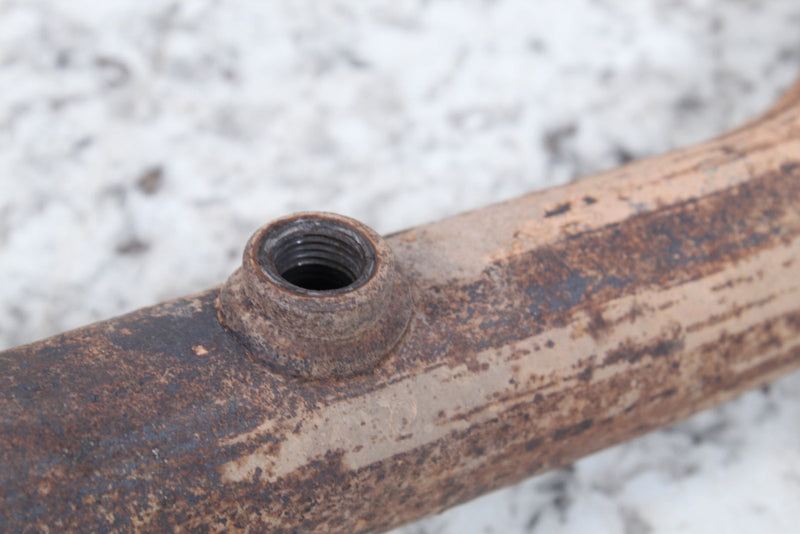 Rusty metal pipe with threaded port.