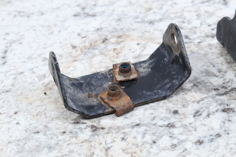 Black metal bracket with rusty fasteners.