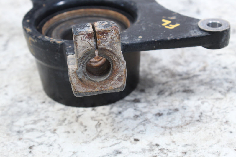 Black metal automotive part with a rusty, split-clamp fitting.