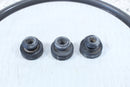 Three weathered, black rubber bushings.
