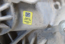 Yellow label on a dirty metal part.