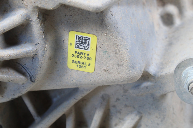 Yellow label on a dirty metal part.